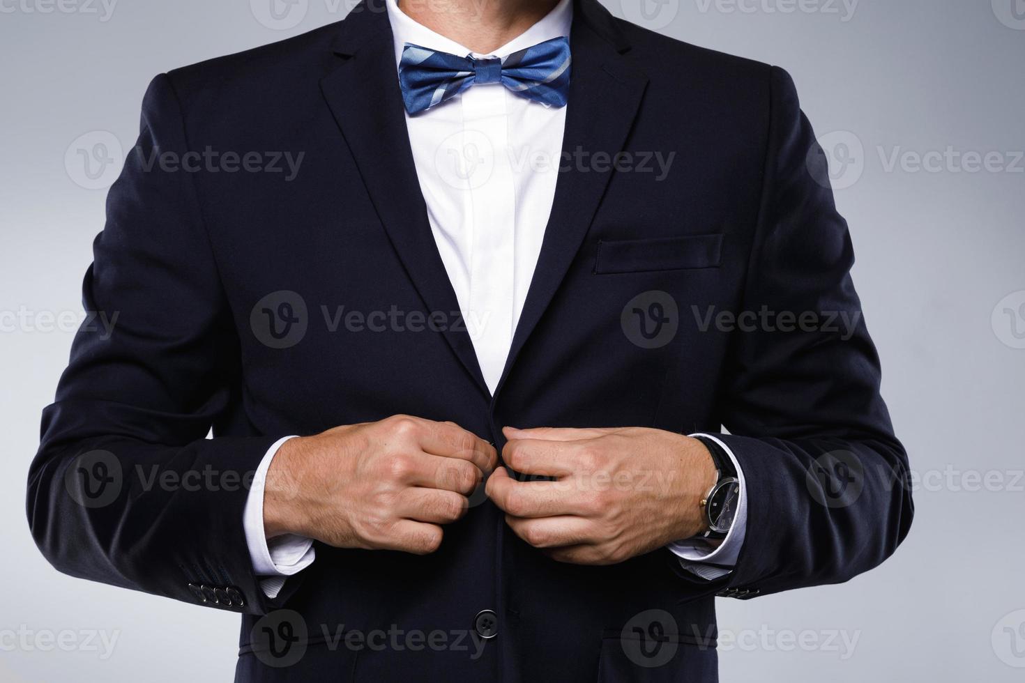 Man in navy blue suit with bow tie photo