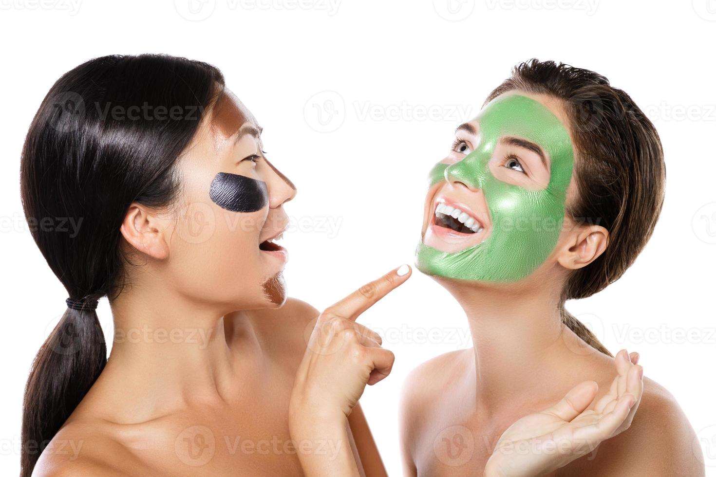 Two beautiful girls with colorful peel-off masks on their faces photo