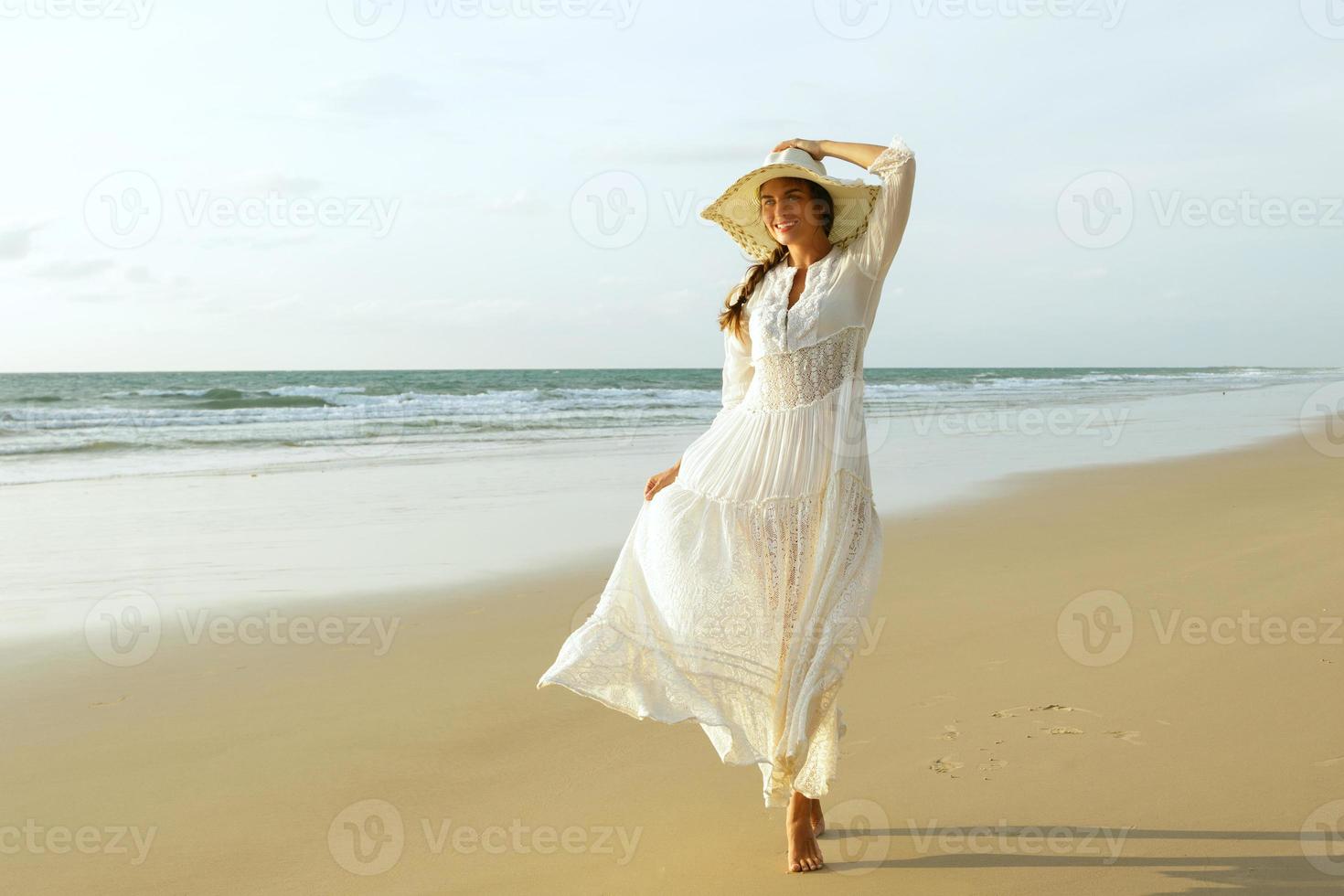 Mujer con vestido blanco en la playa.