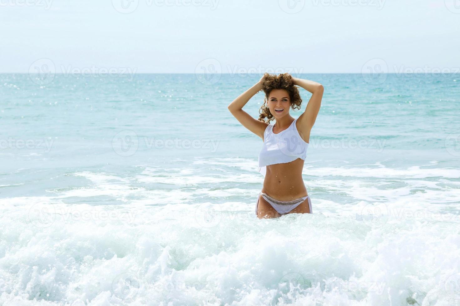 Beautiful woman in a wet shirt in the sea photo