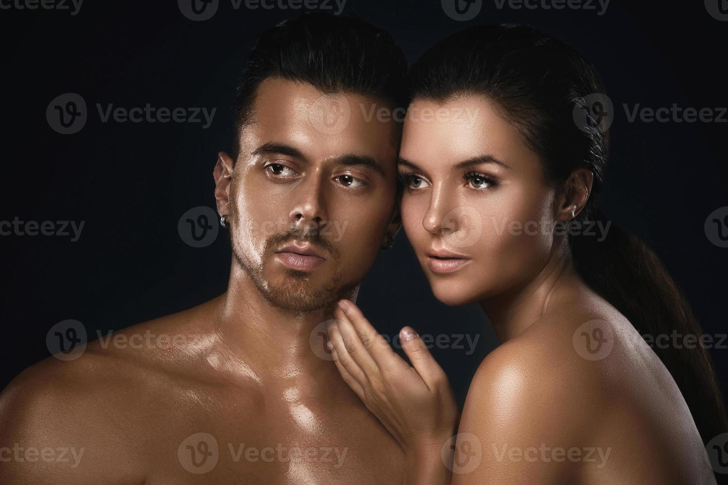 Young beautiful couple in studio on black background photo