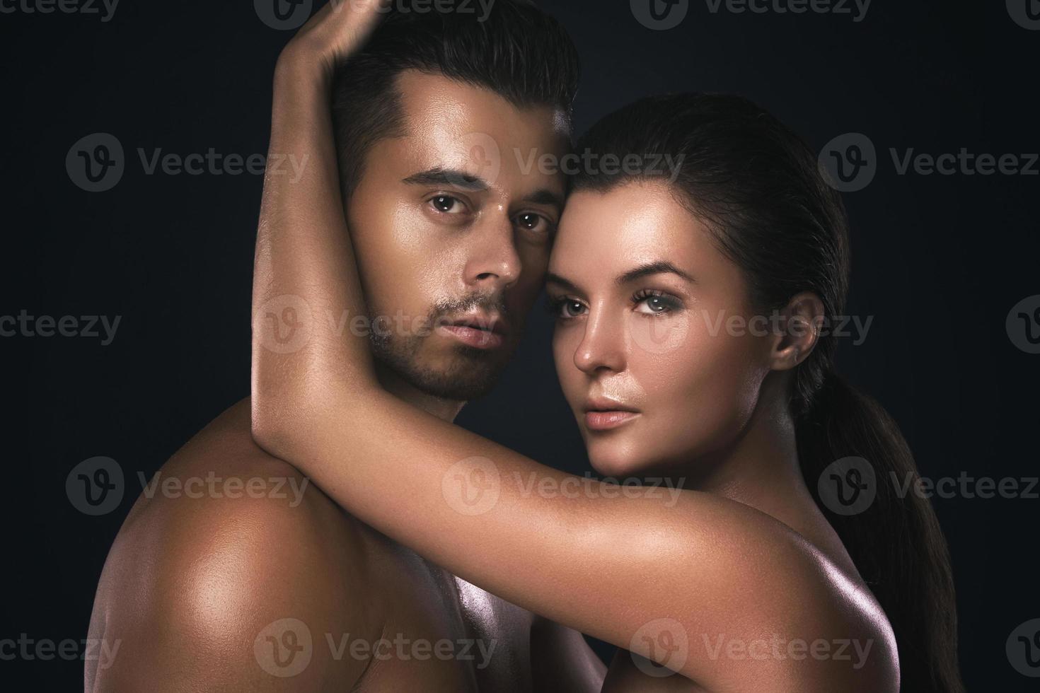 Young beautiful couple in studio on black background photo