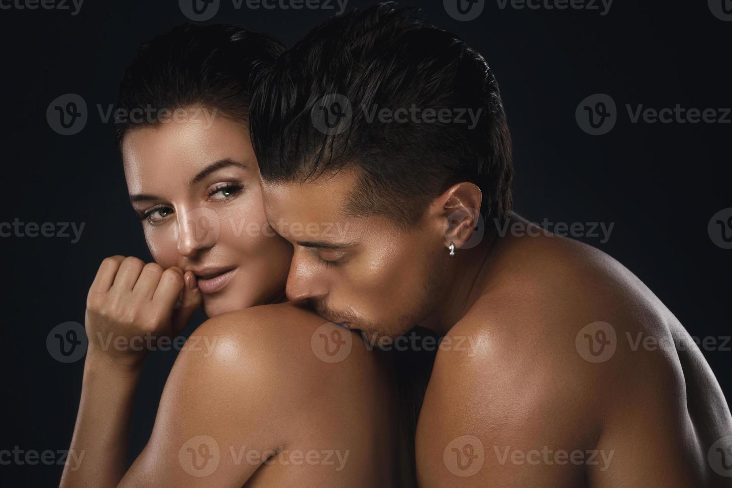 Young beautiful couple in studio on black background photo