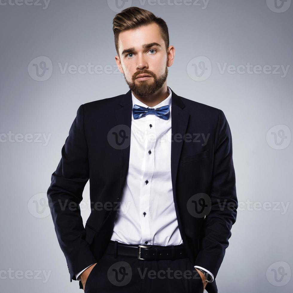 Stylish handsome man wearing a classic suit with bow-tie photo