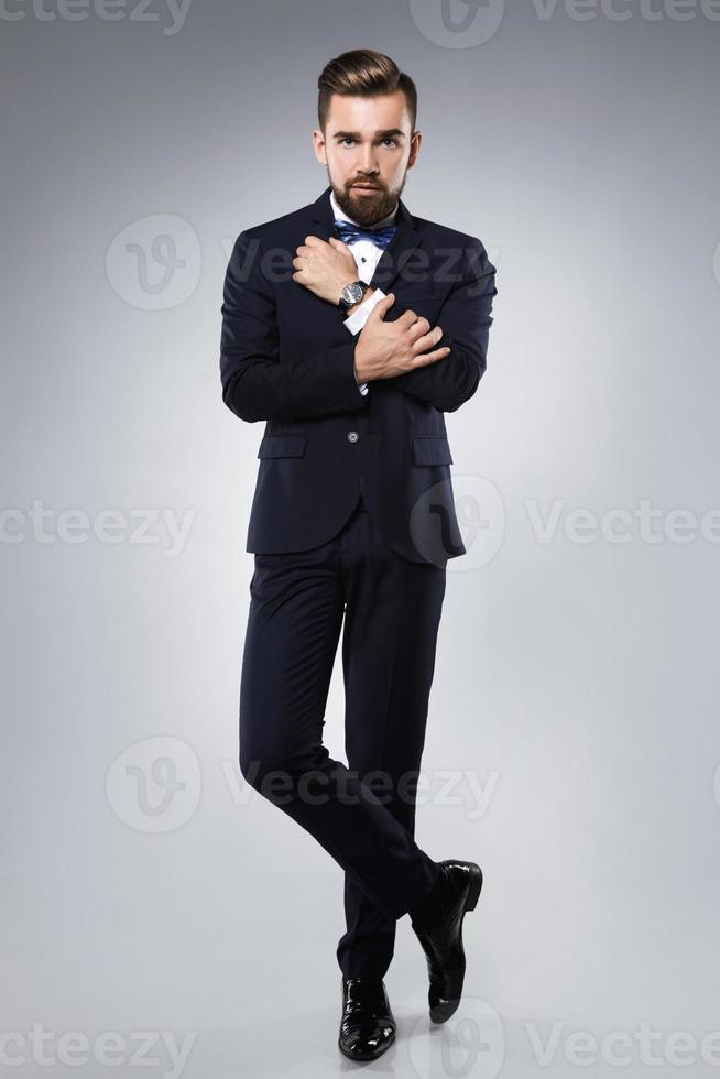 Stylish handsome man wearing a classic suit with bow-tie photo