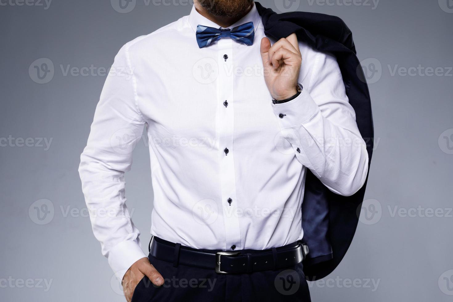 Stylish man wearing bow tie on gray background photo