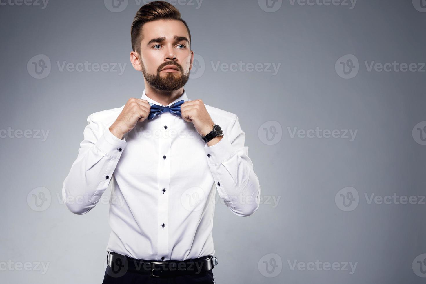 Stylish handsome man wearing a classic suit with bow-tie photo