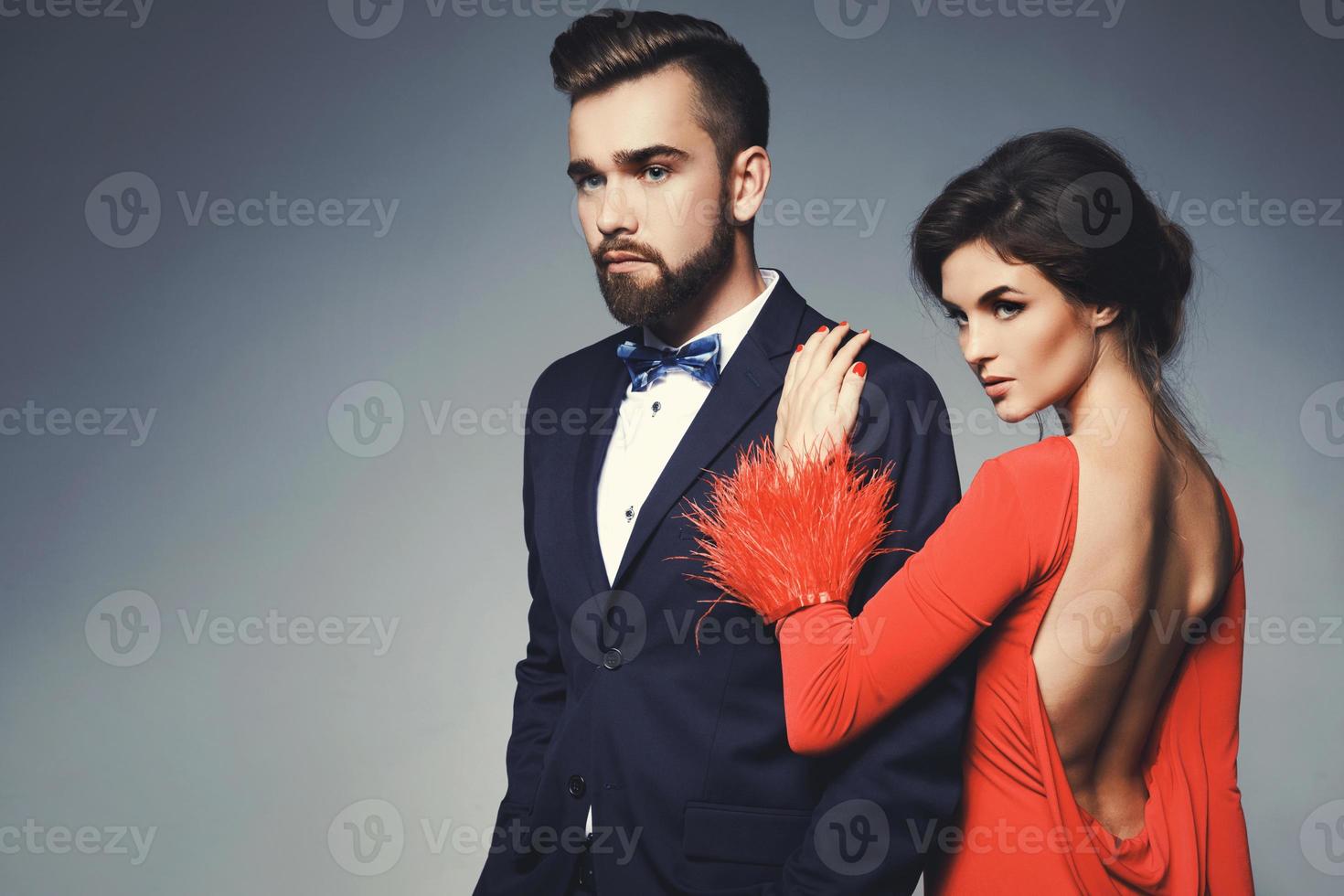 Woman in beautiful red dress and man wearing blue classical suit with bow tie. photo