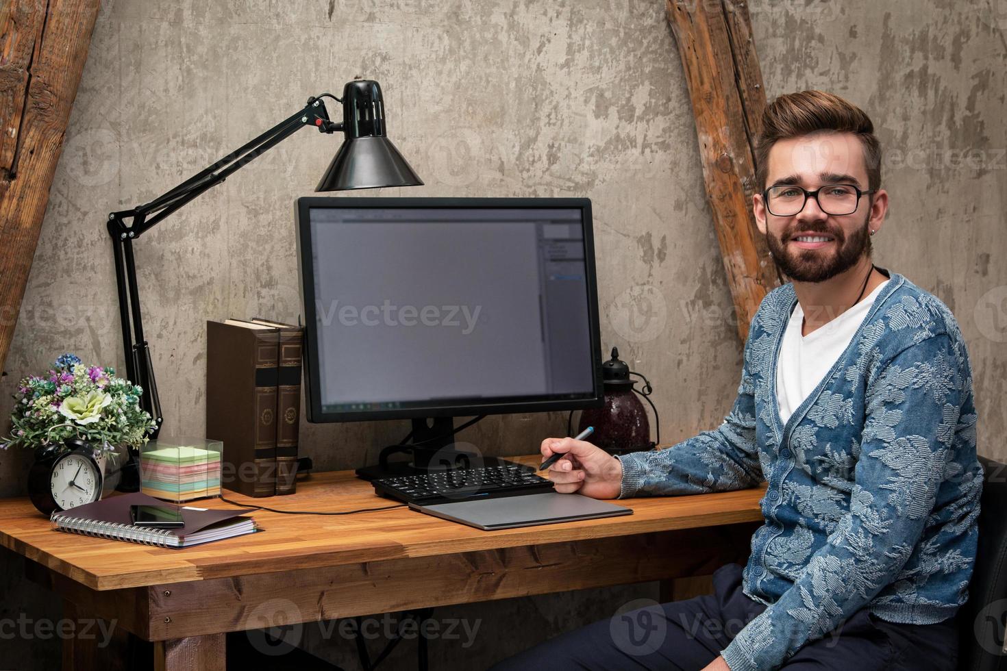 diseñador gráfico joven y guapo trabajando en su lugar de trabajo foto