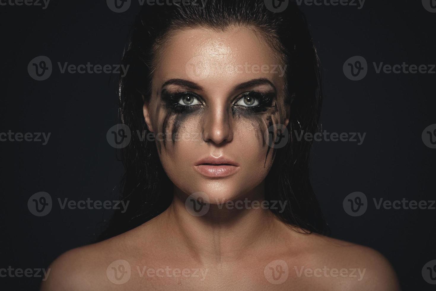 Sad and beautiful woman with smudged makeup on her face photo