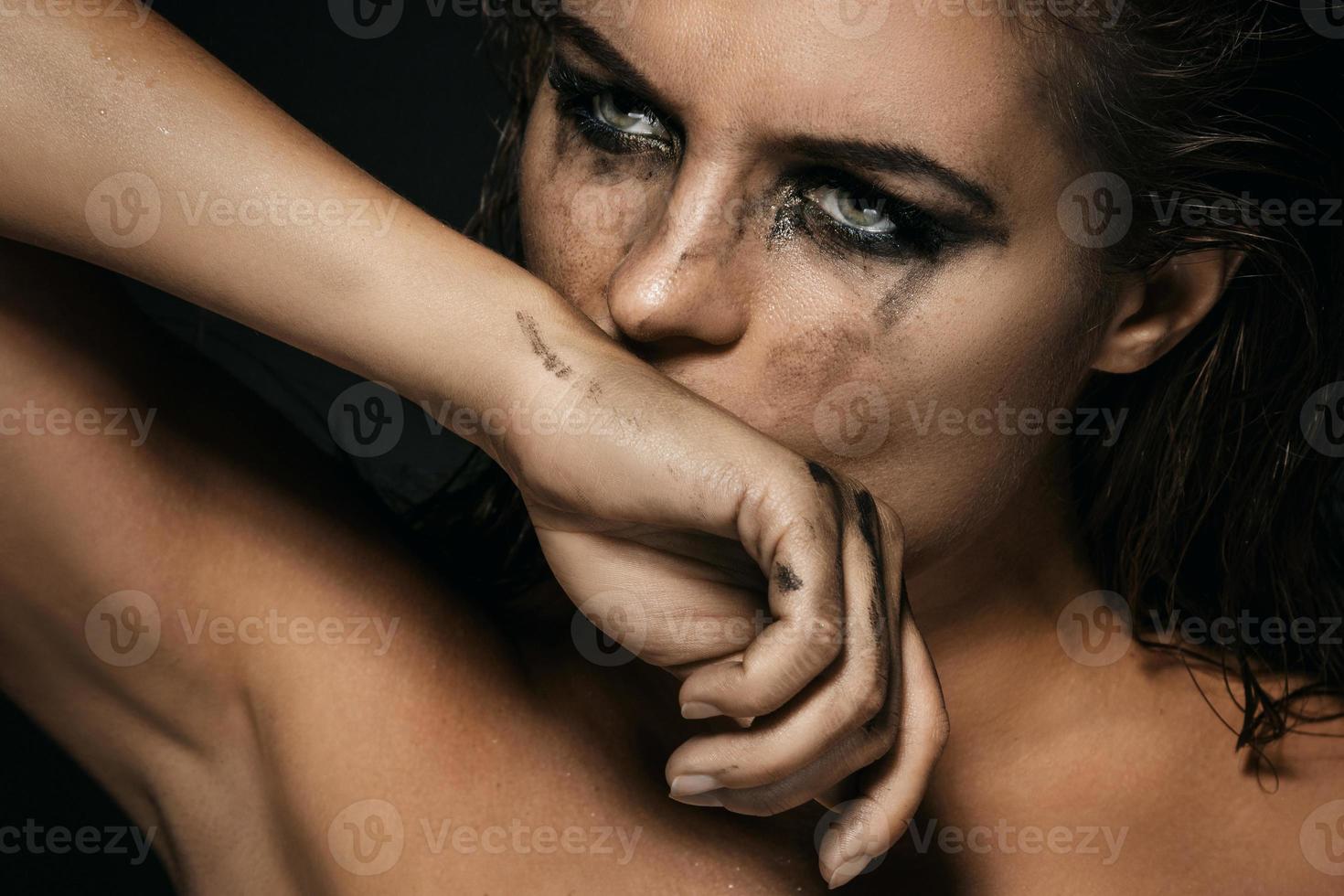 Beautiful woman with smudged makeup on her face photo