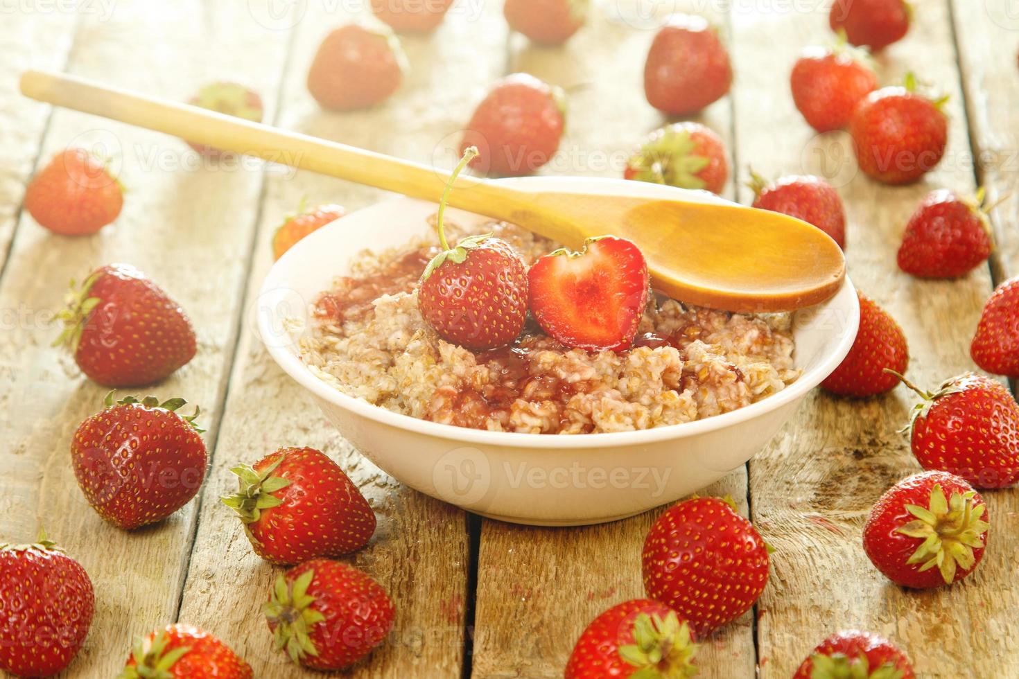 Cooked oatmeal, ripe berries and strawberry jam photo