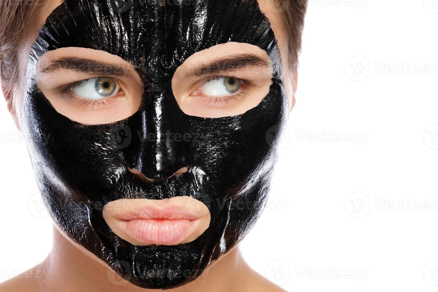 Woman with purifying black mask on her face photo