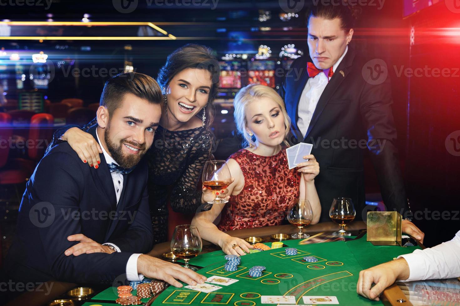 Group of rich people is playing poker in the casino photo