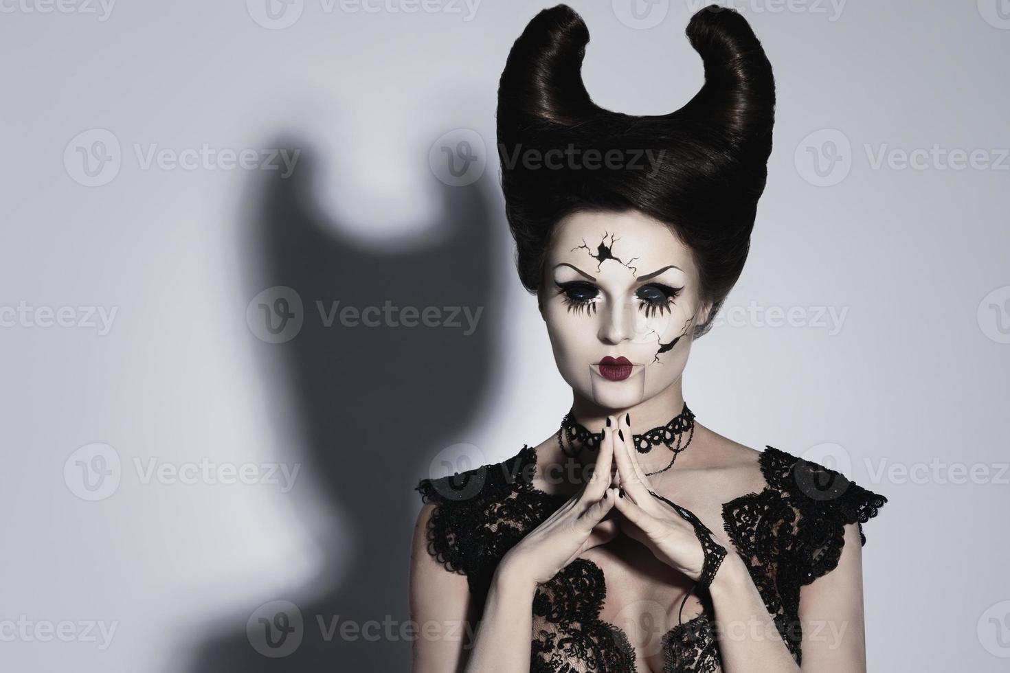 Spooky porcelain doll with horns on her head. photo