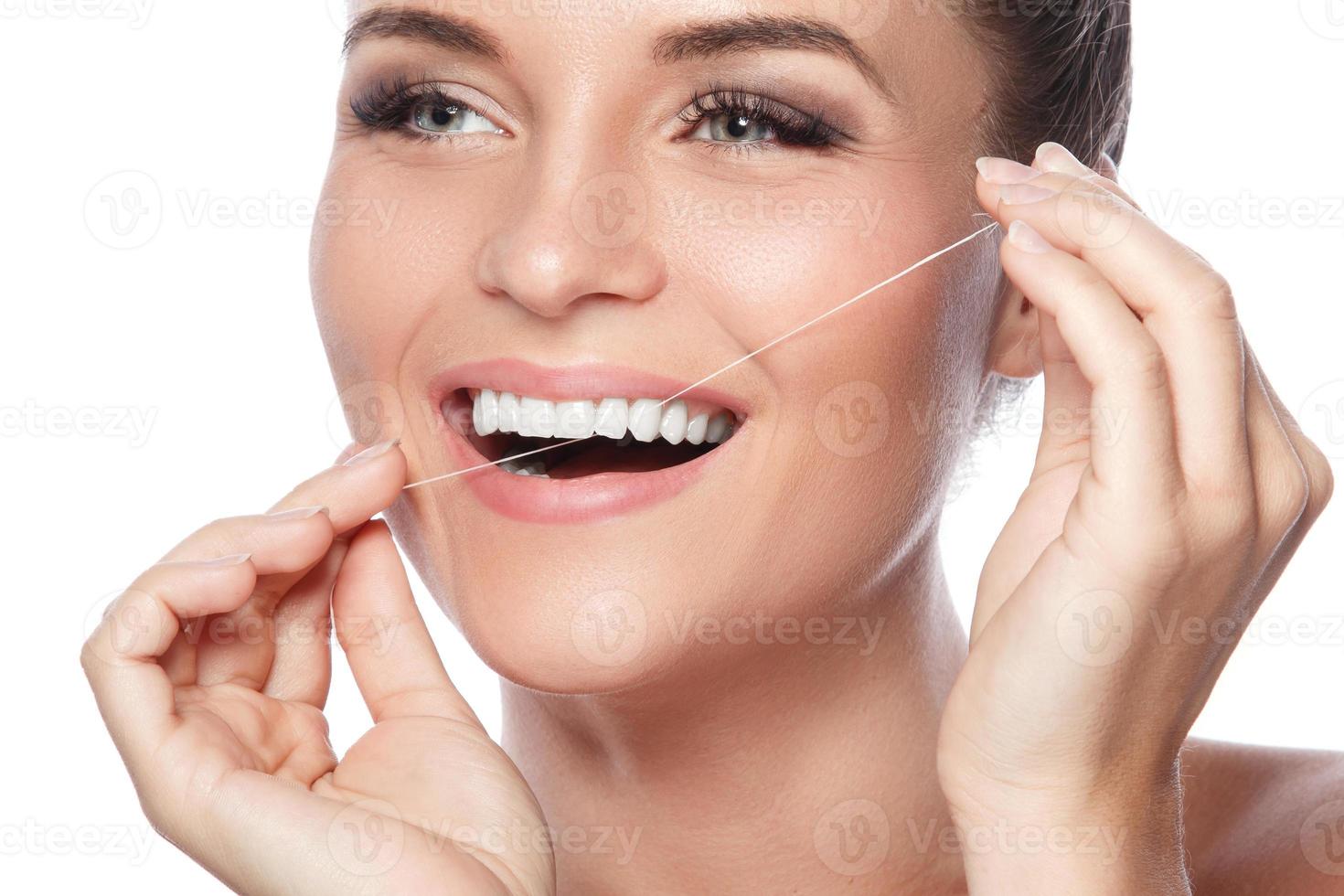 mujer e hilo dental sobre fondo blanco foto