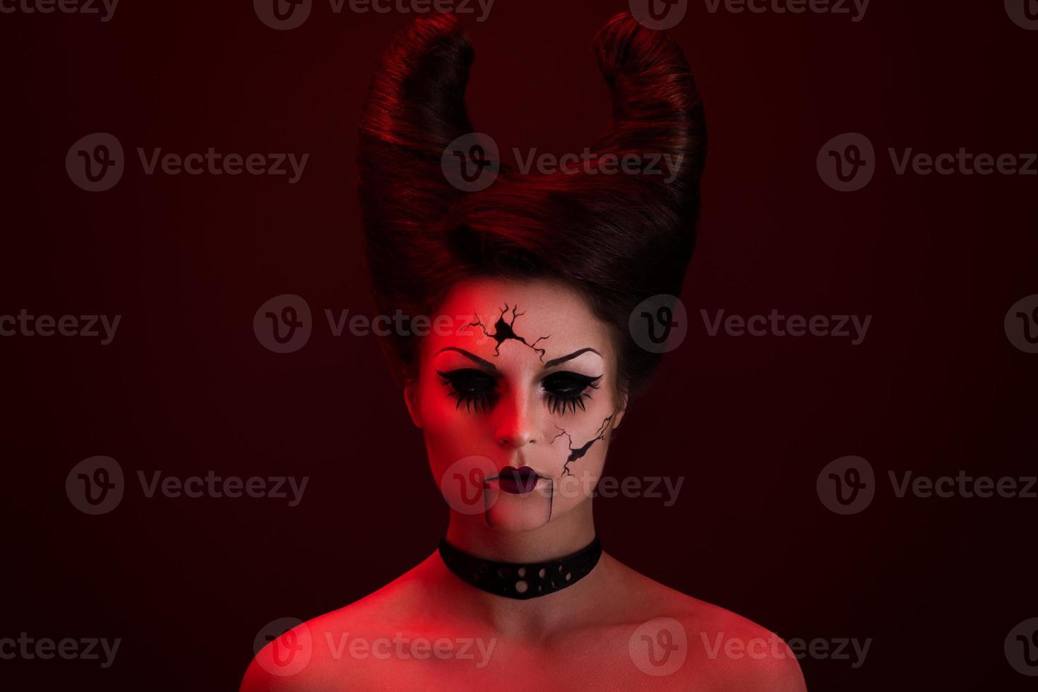 Spooky porcelain doll with horns on her head photo
