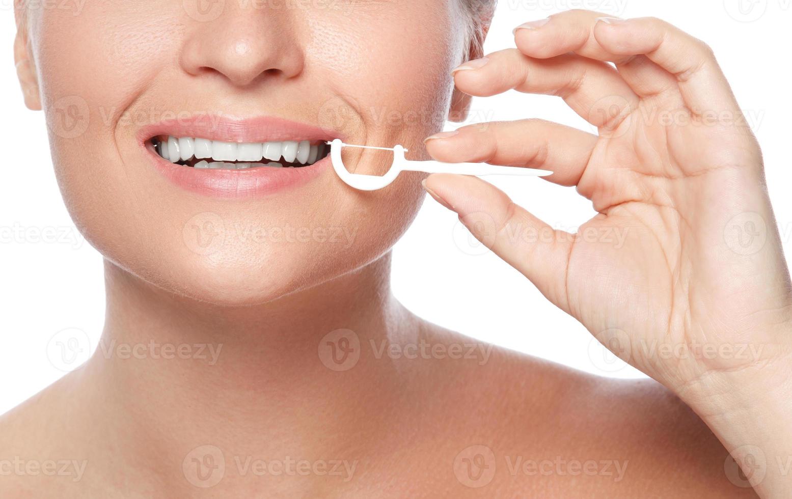 Woman with dental floss pick on white background photo