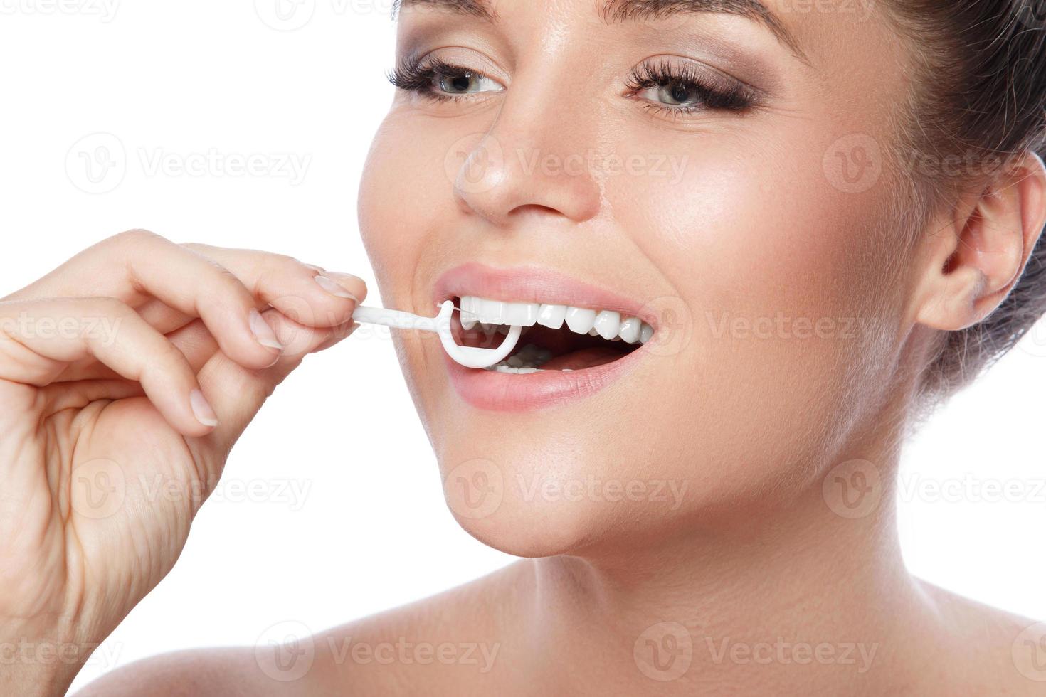 Woman with dental floss pick on white background photo