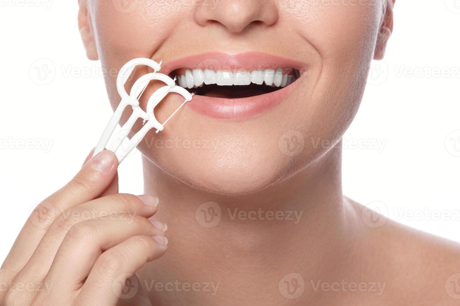 Woman with dental floss pick on white background photo