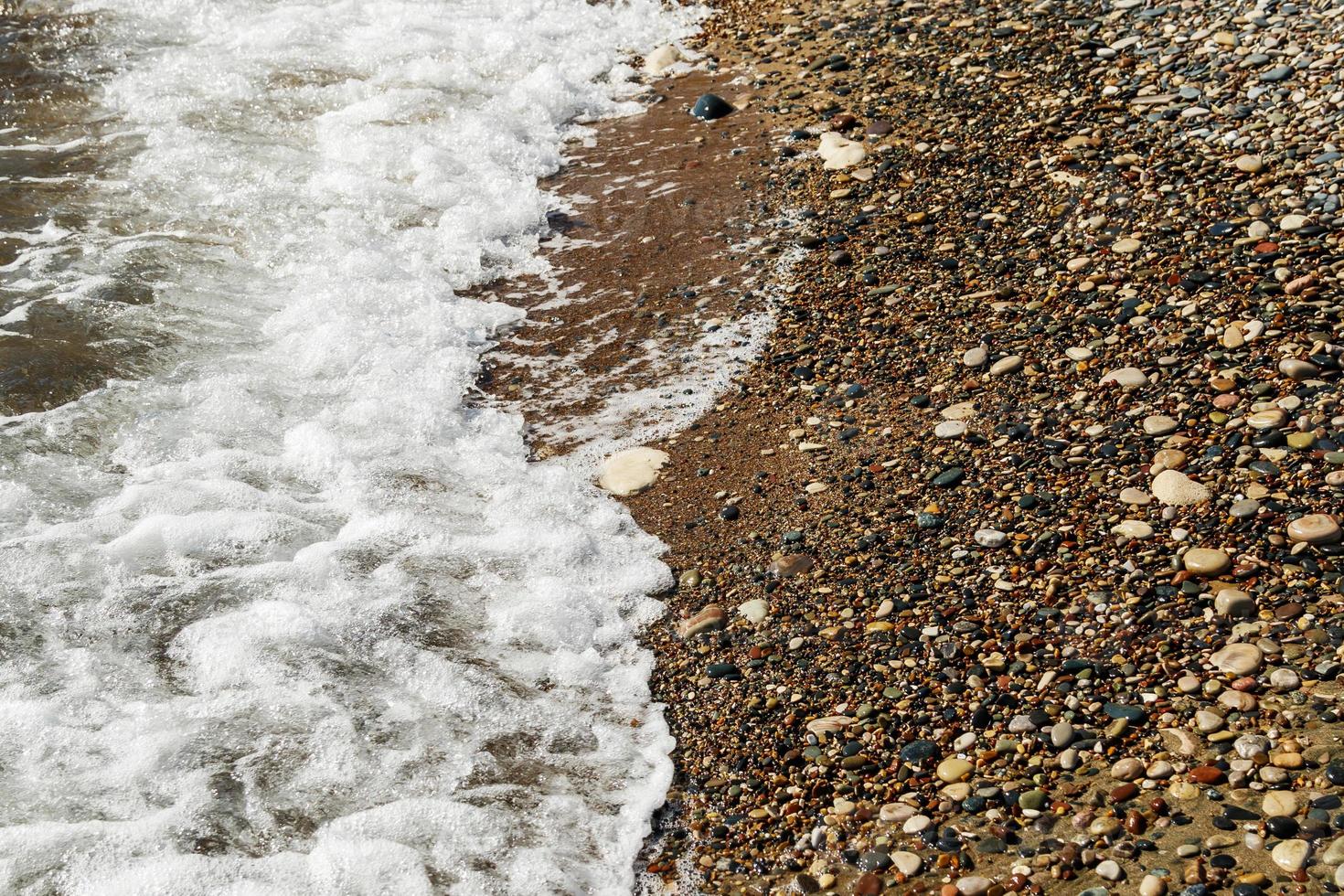 fondo de piedras de guijarros en la playa foto