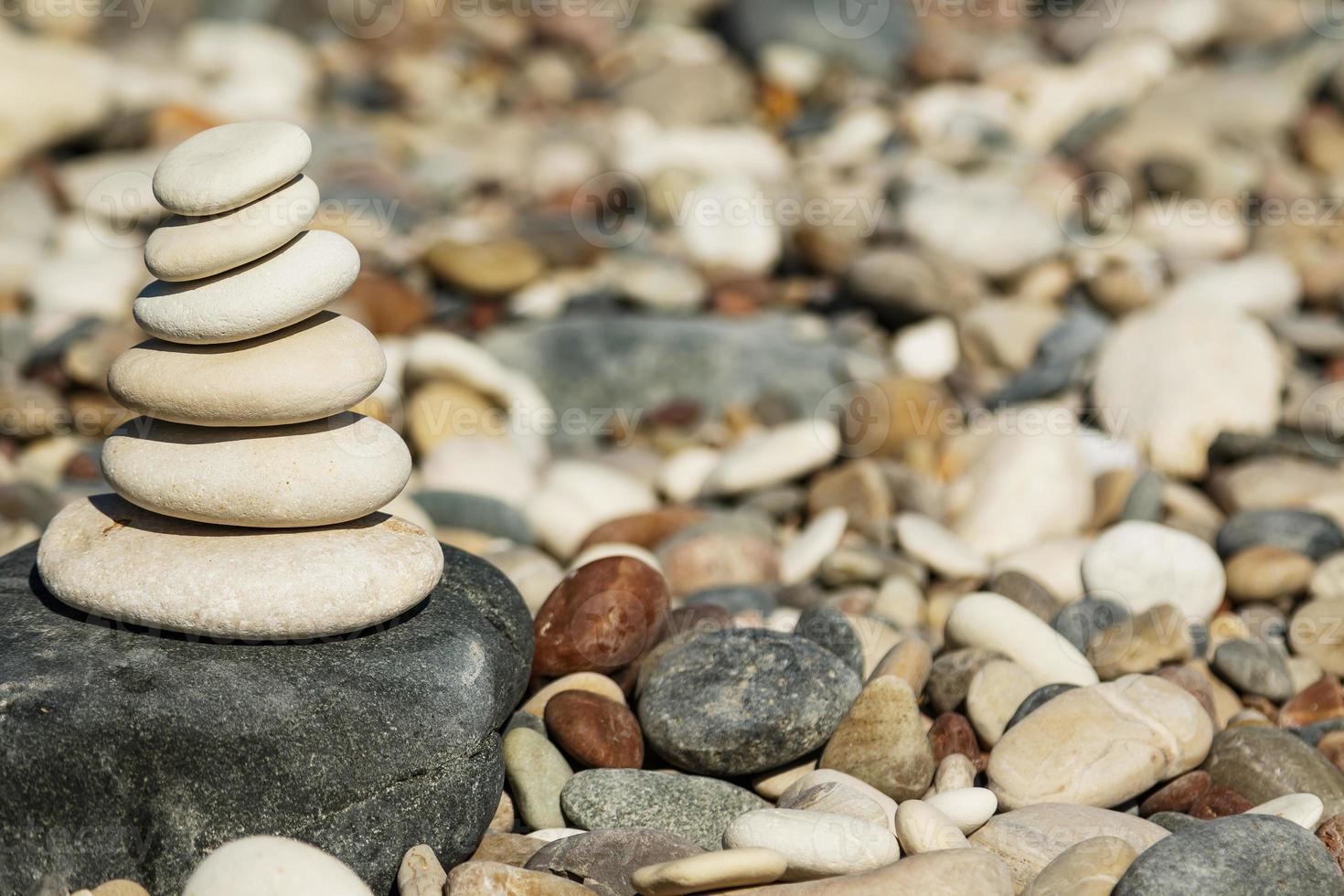 Stack of smooth round stones on pebble beach photo
