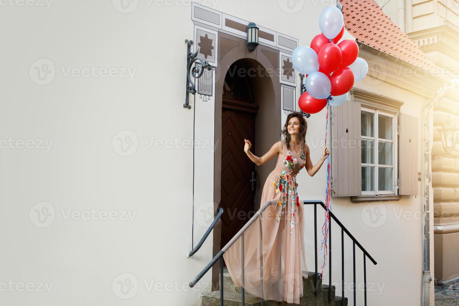 Woman in beautiful dress with a lot of colorful balloons photo