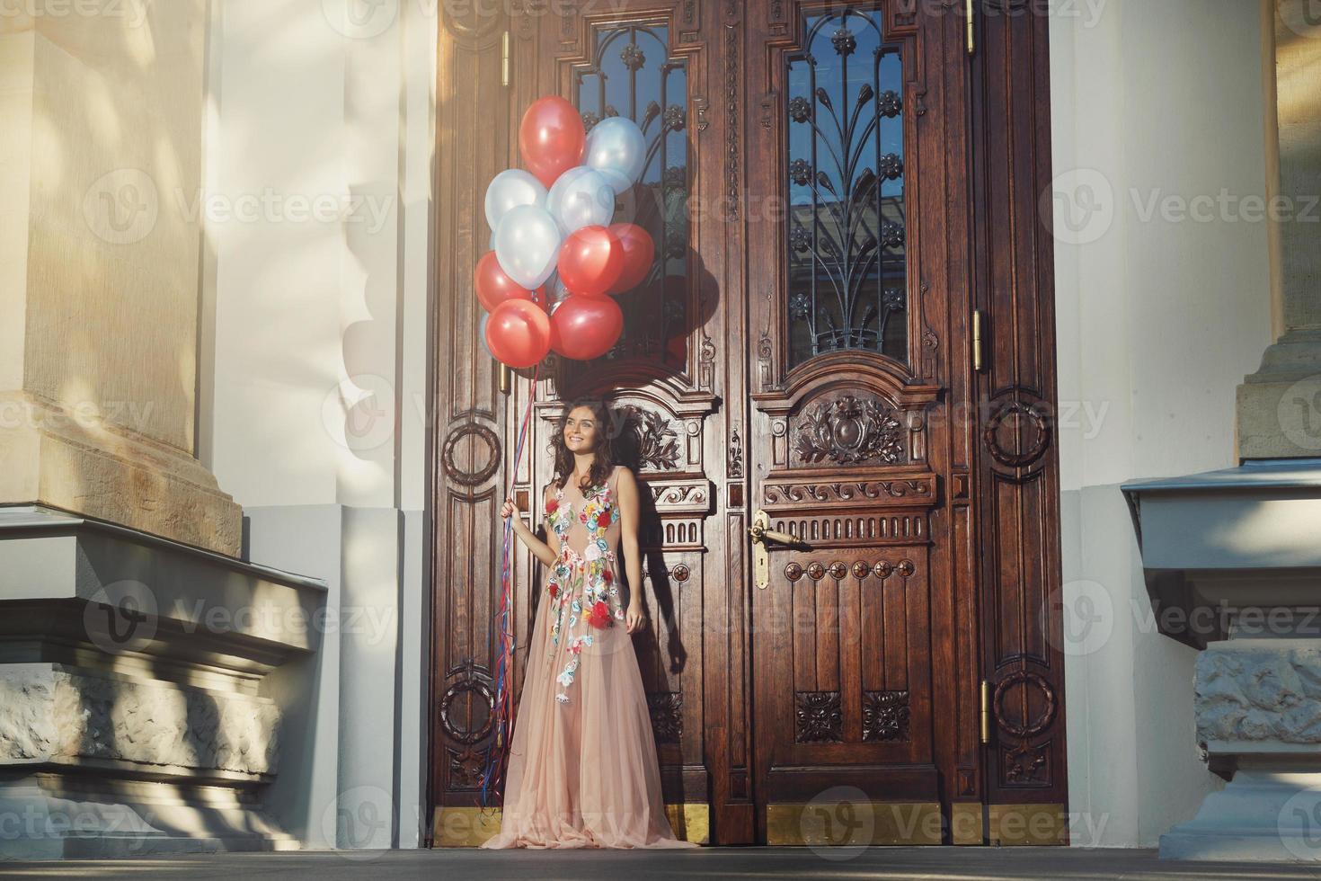 Woman in beautiful dress with a lot of colorful balloons photo