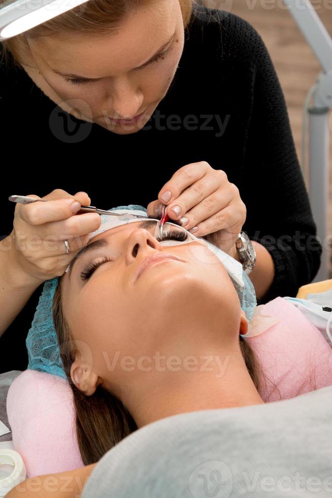 Procedure of eyelashes extension in beauty salon photo