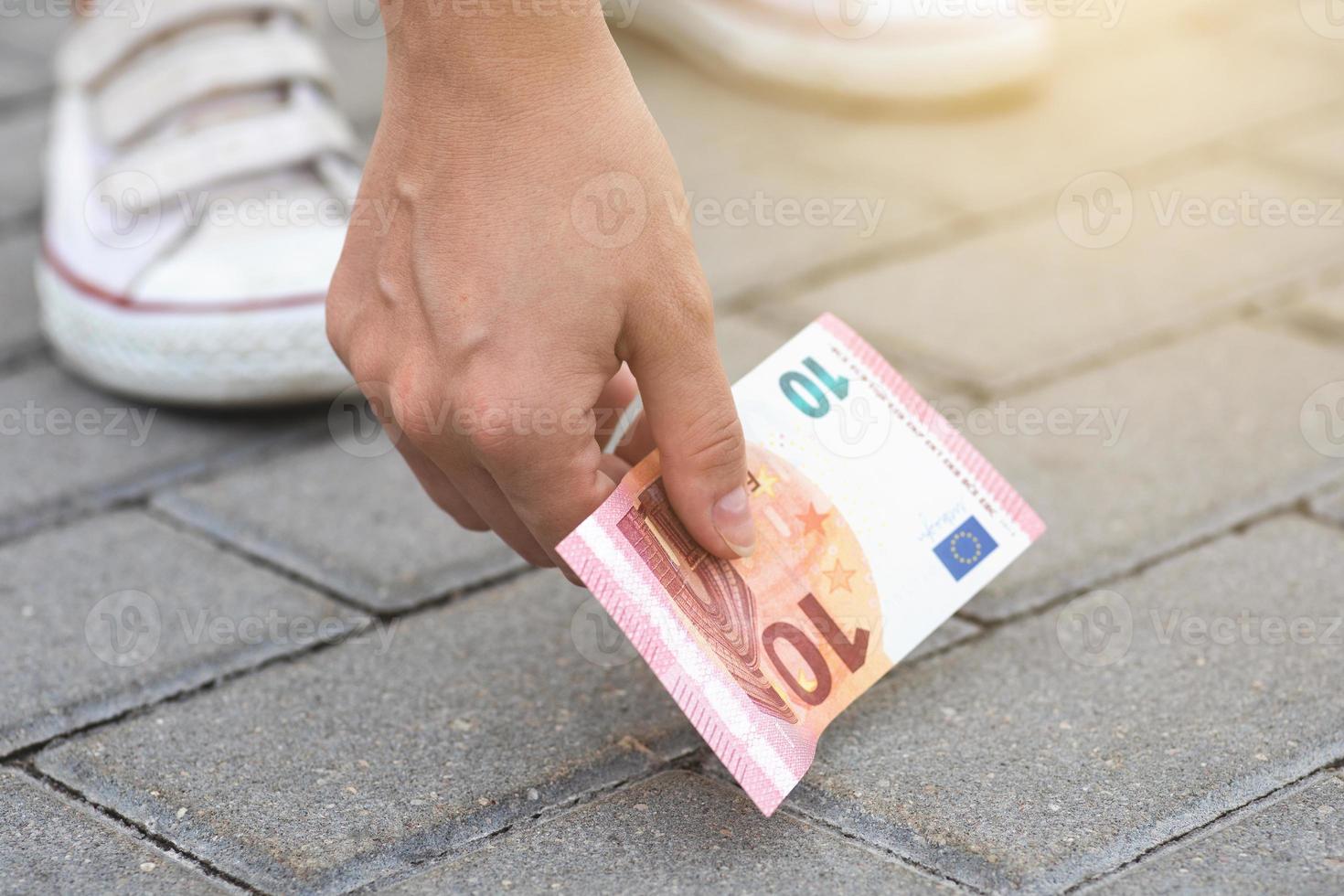 mujer está recogiendo billetes de diez euros del suelo foto