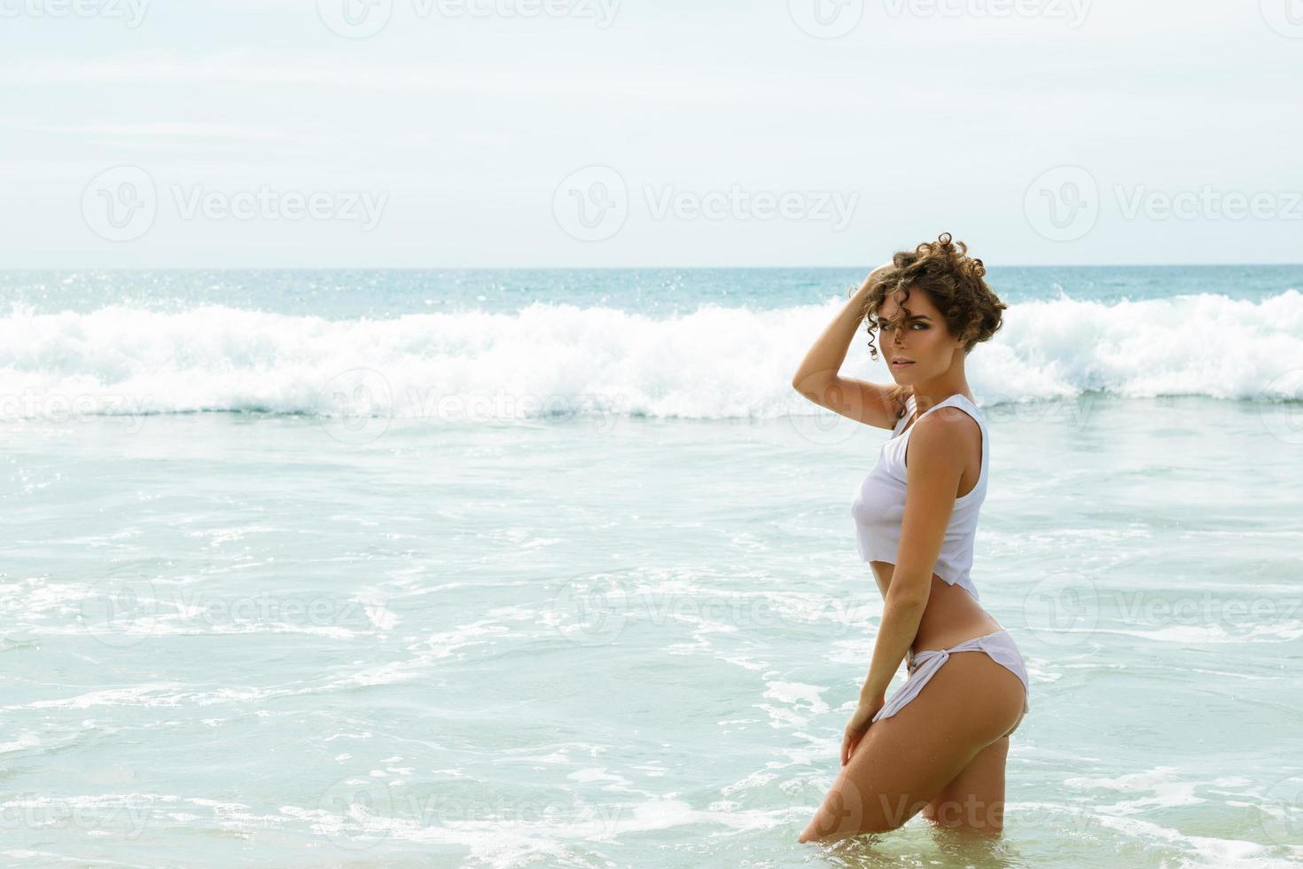 Beautiful woman in a wet shirt in the sea photo
