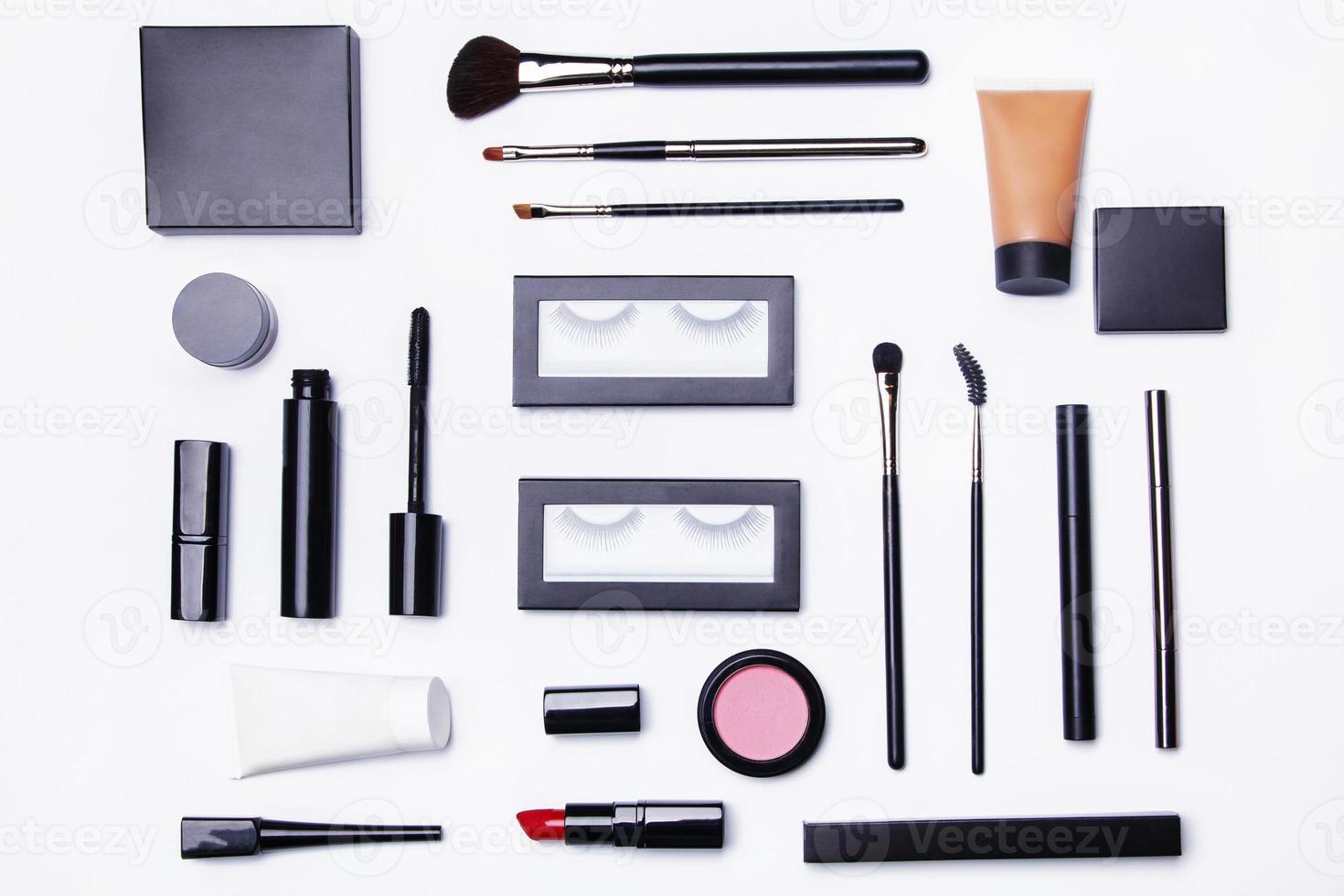 Different makeup objects and cosmetics on white photo