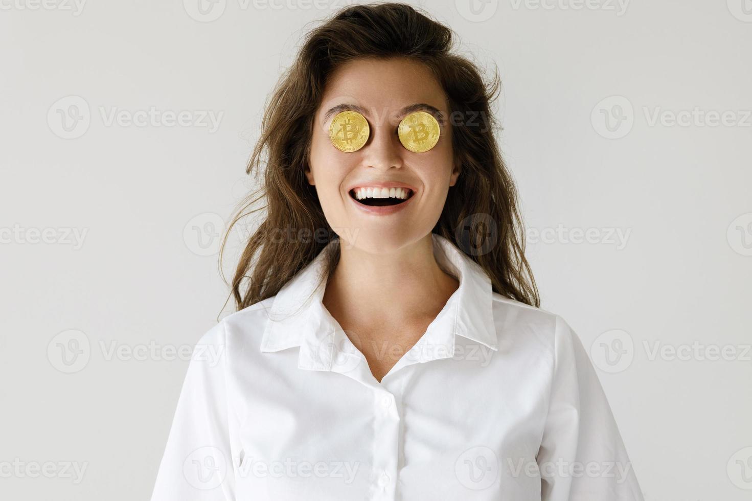 Young woman with a Bitcoin cryptocurrency on gray background photo