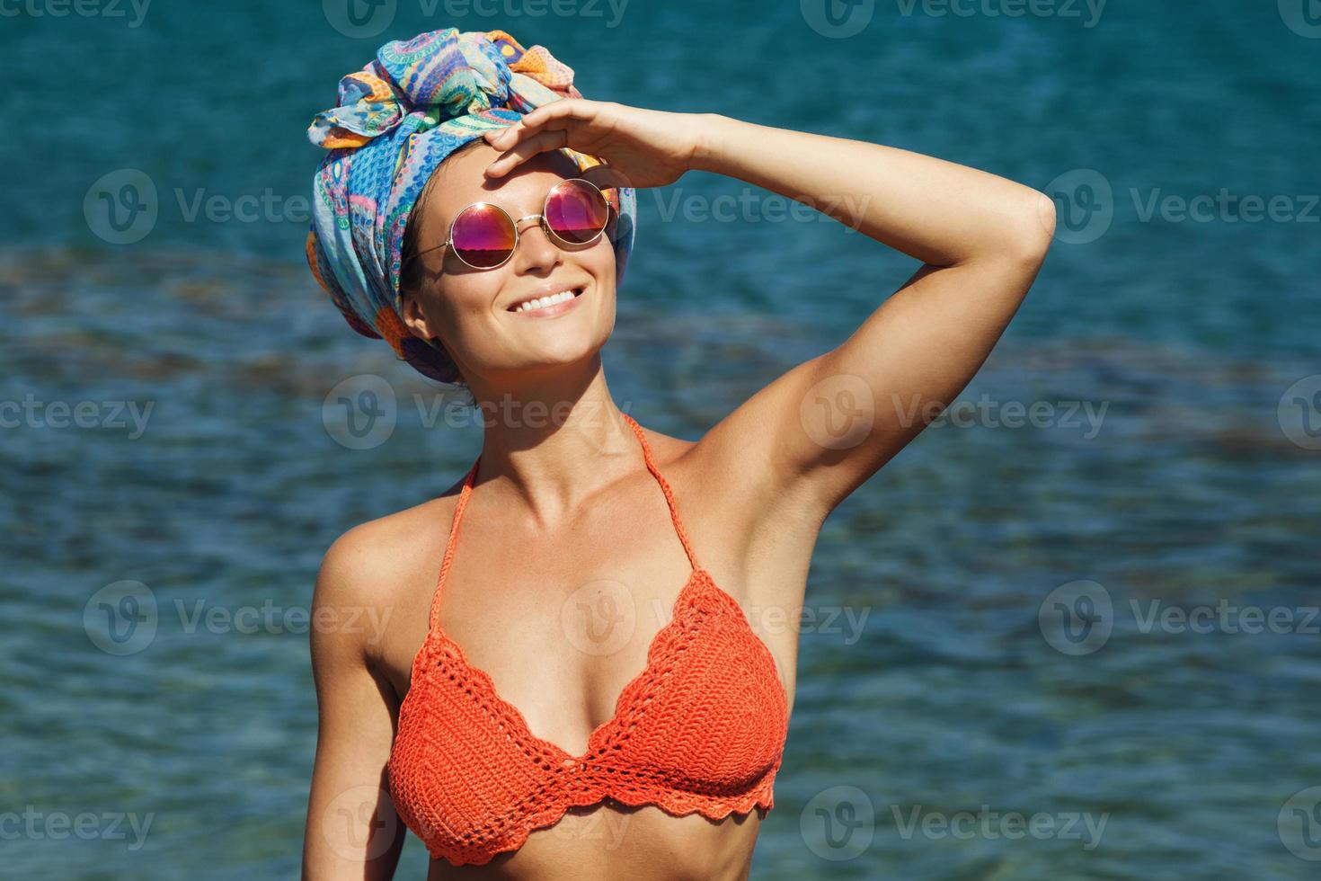 mujer en bikini y gafas de sol la playa foto