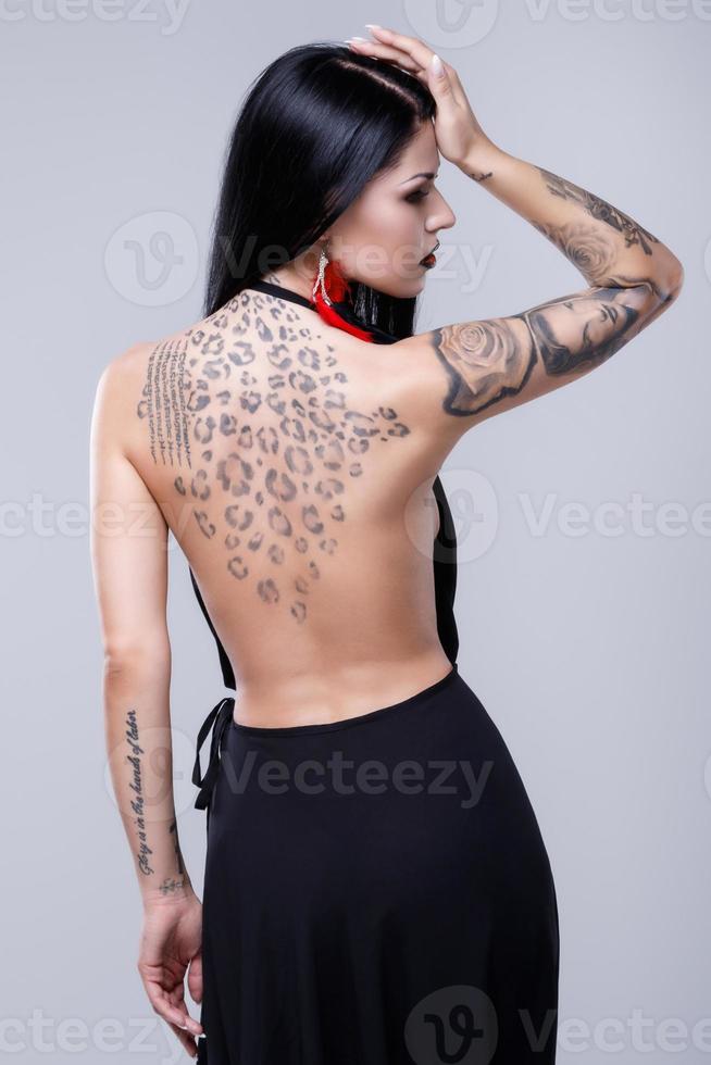 Portrait of woman with tattoos wearing black dress photo