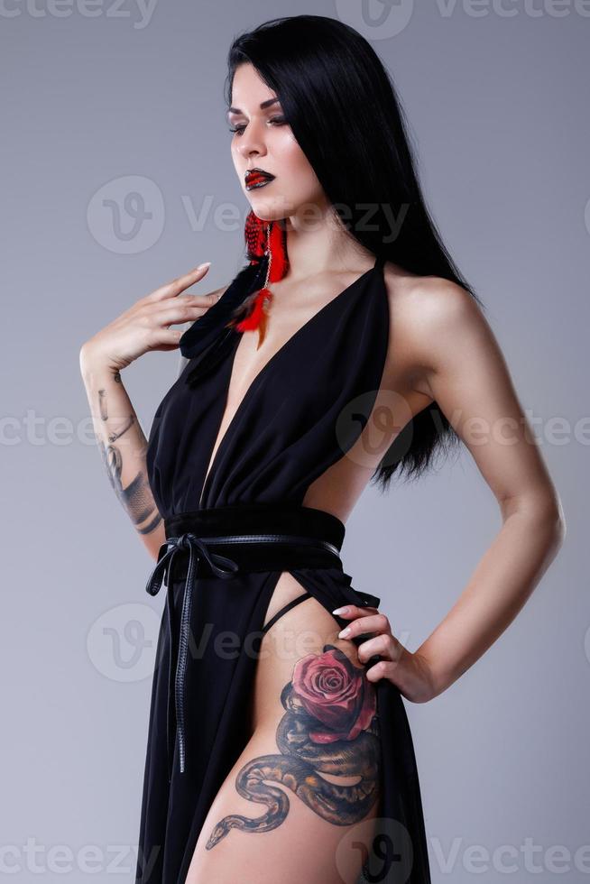 Portrait of woman with tattoos wearing black dress photo