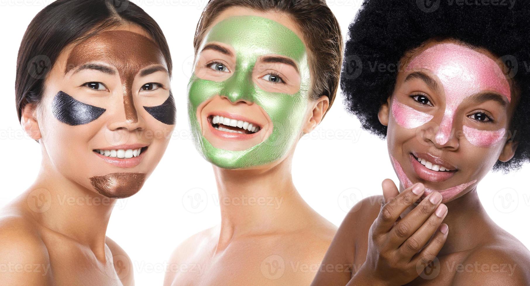 Beautiful multi-ethnic girls with colorful peel-off masks on their faces photo