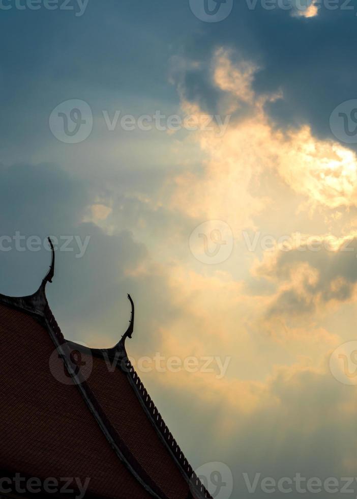 Sun beam behind the sunset clouds over the buddhist temple photo