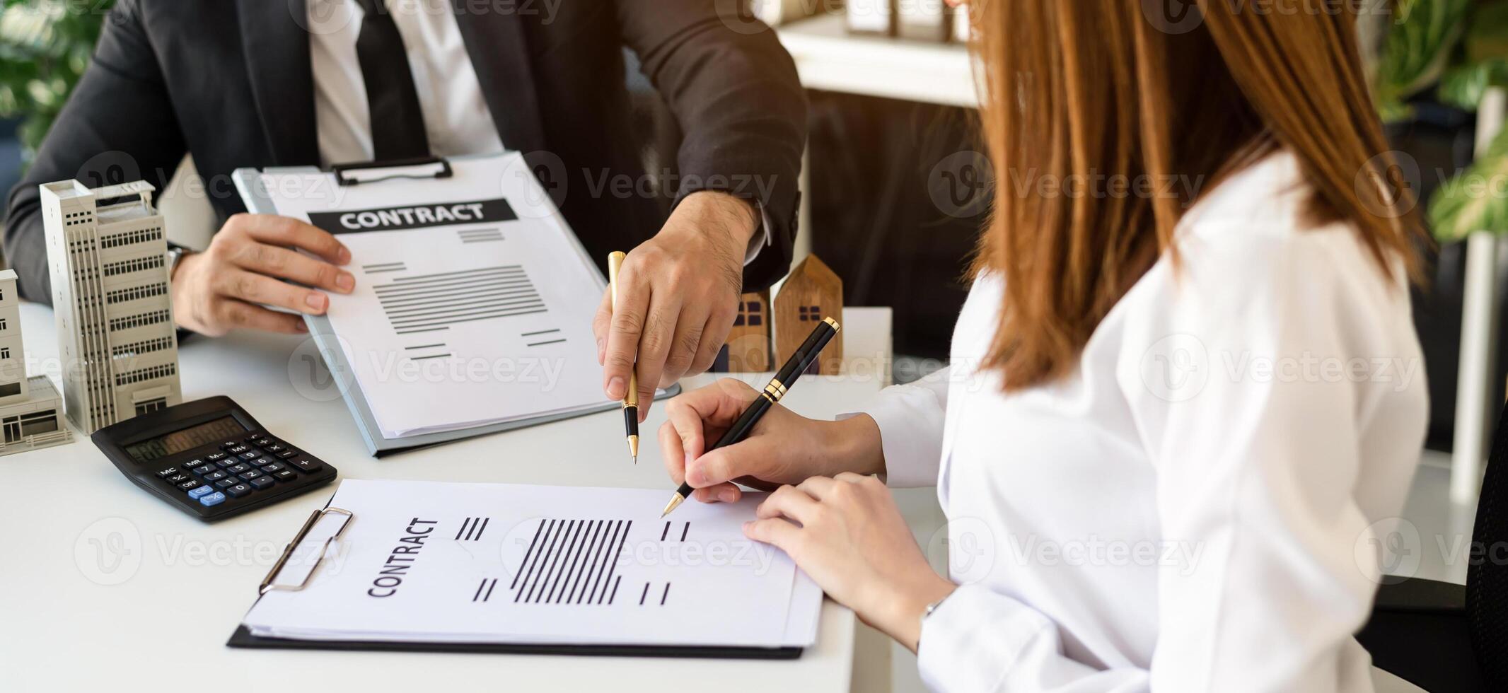 Signing a contract. Client and broker agent, lease agreement, successful deal and  Young business sitting at the desk in office photo