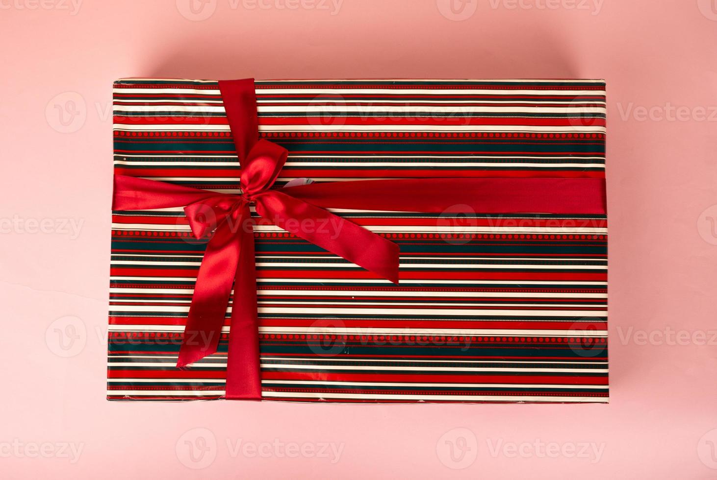 wrapped colorful gift on pink background photo