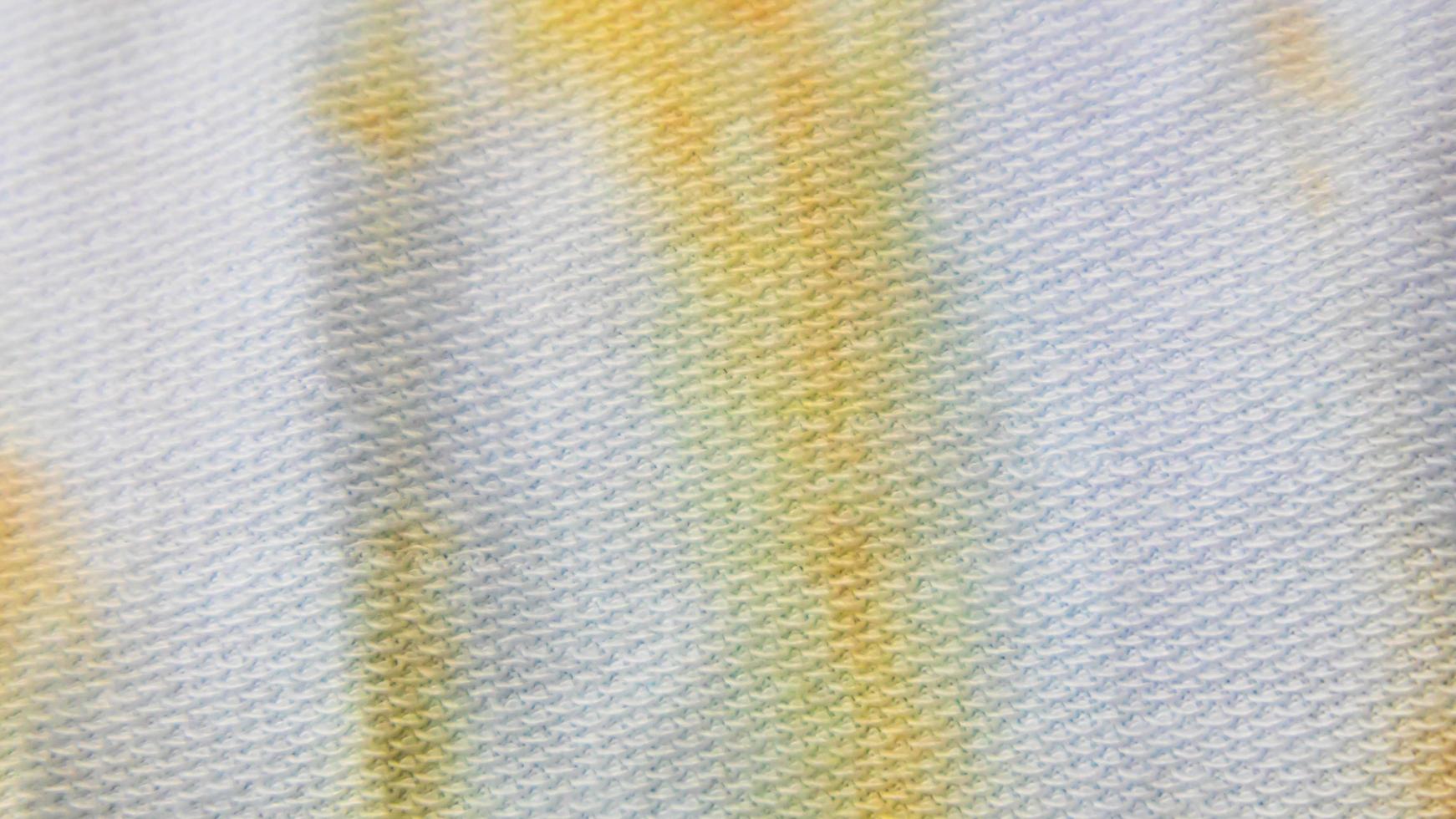 white cloth texture with yellow and blue patterns as background photo