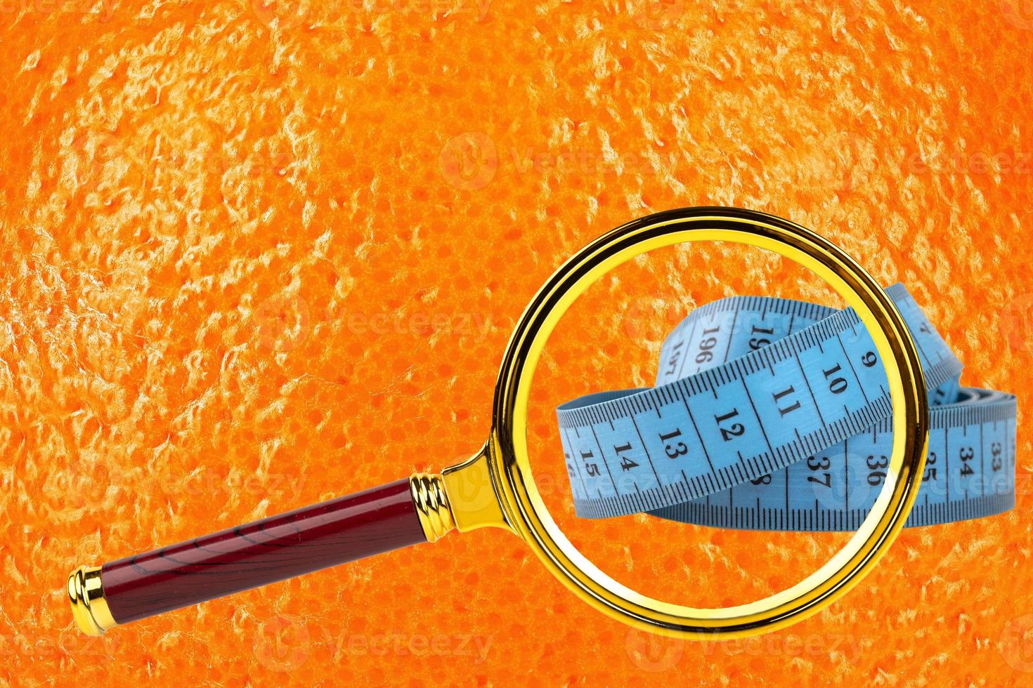 Diet, cellulite, orange peel texture concept image, skin with magnifying glass and blue centiment. photo