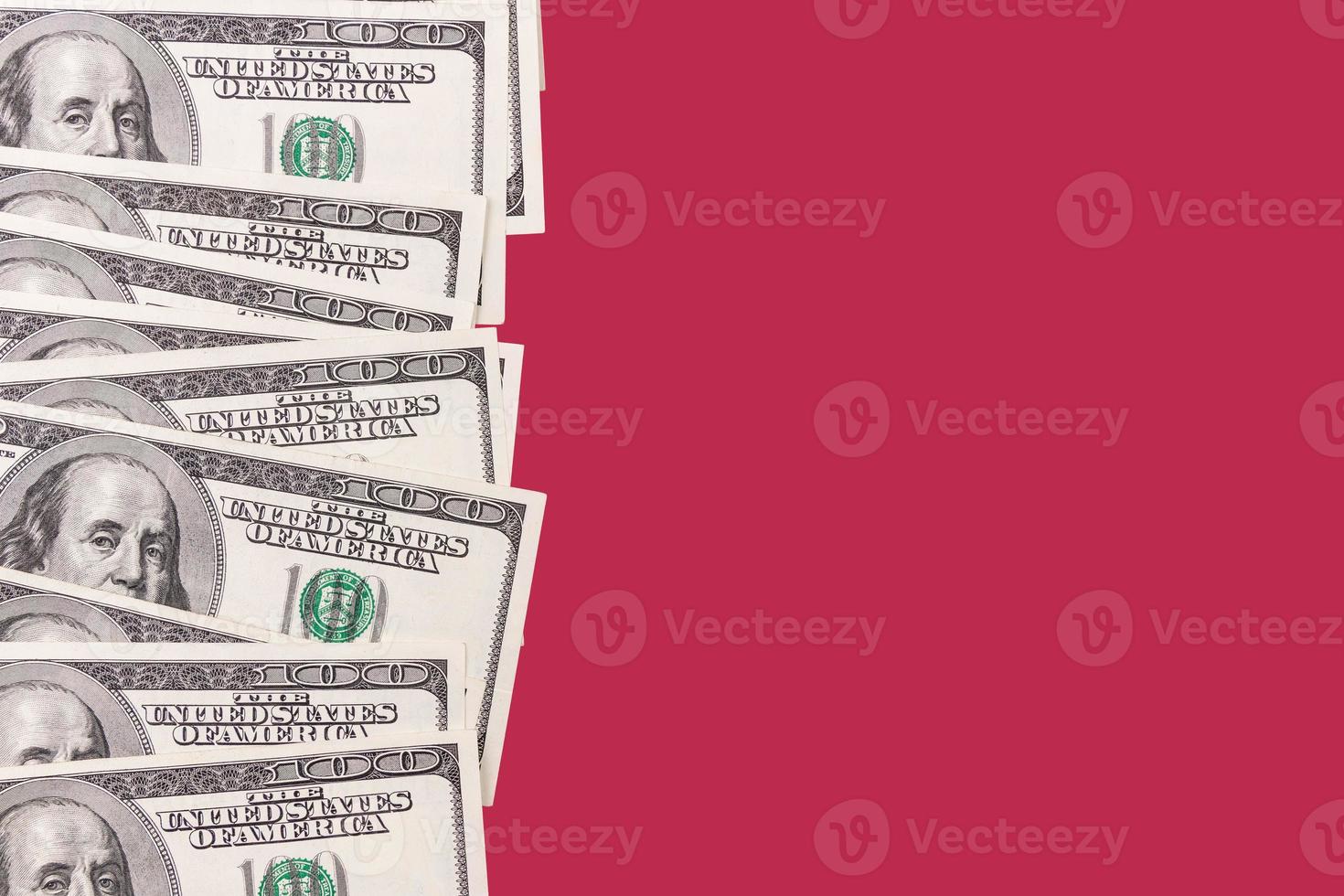 Paper money, background of one hundred dollar bills on a carmine red background. copy space. photo