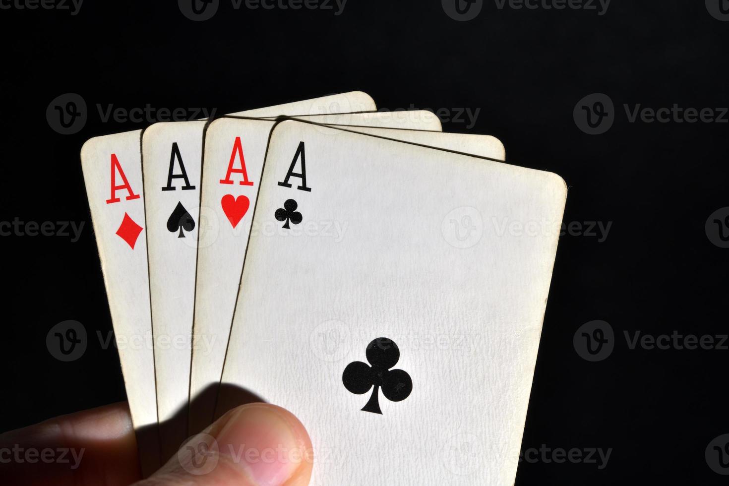 Four aces in hand over black background photo