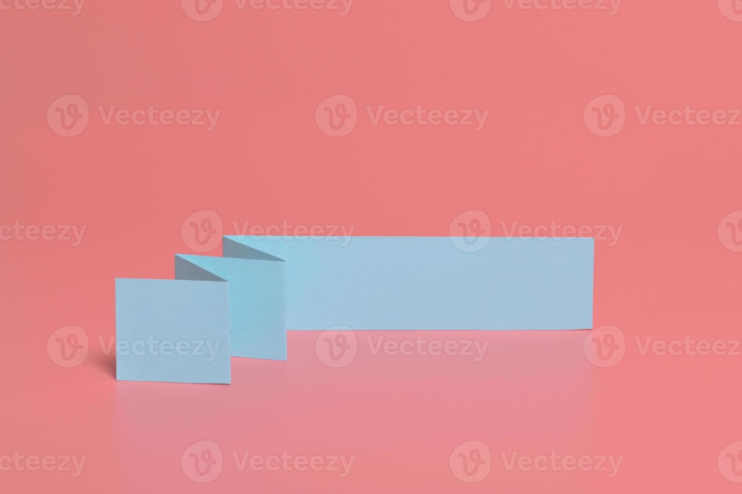 Blue paper isolated on pink background photo