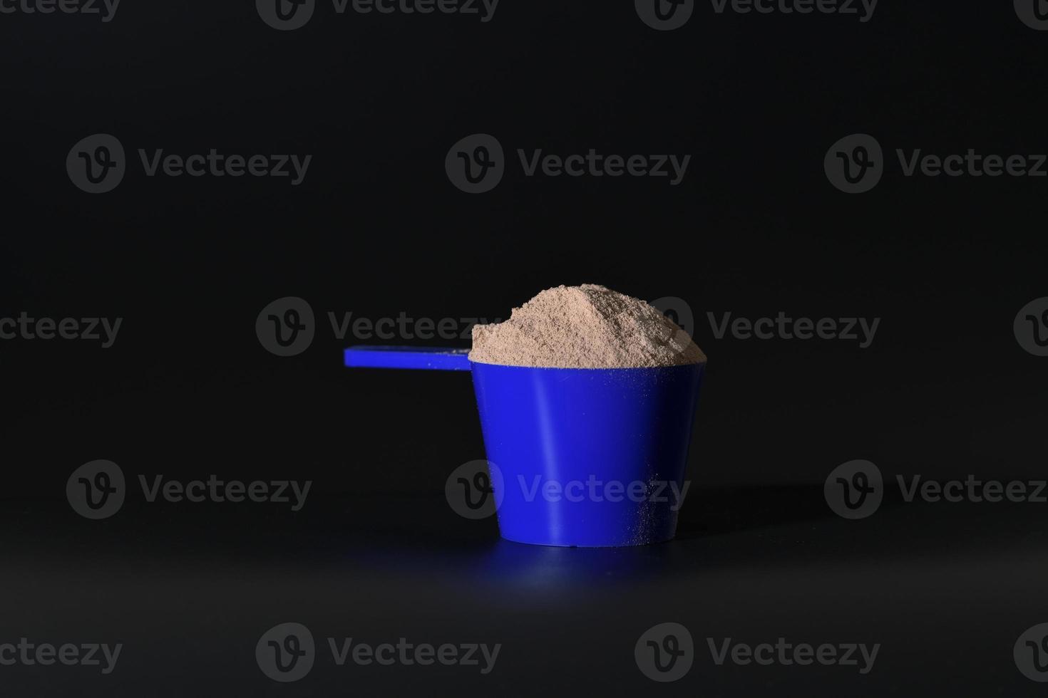 Whey protein in blue measuring scoop. Food supplement photo