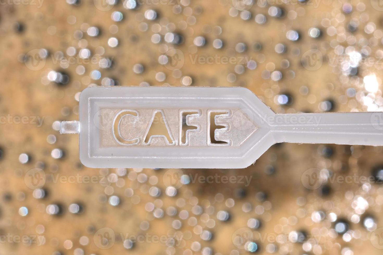 Plastic coffee spoon over coffee foam photo