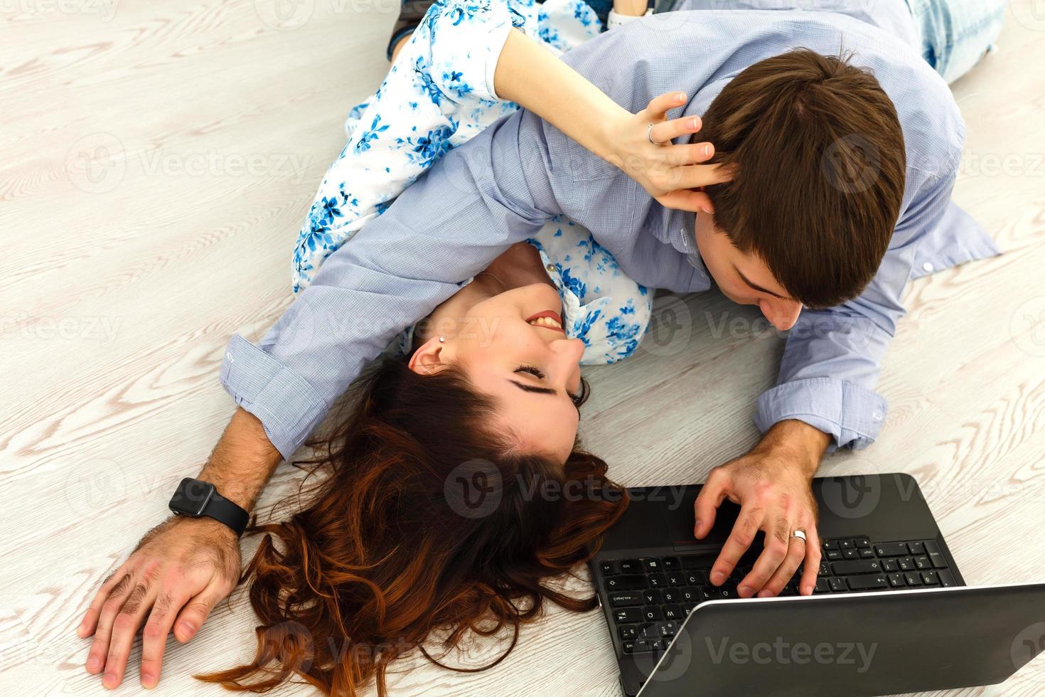 Couple buying online together with a laptop on a desktop at home photo
