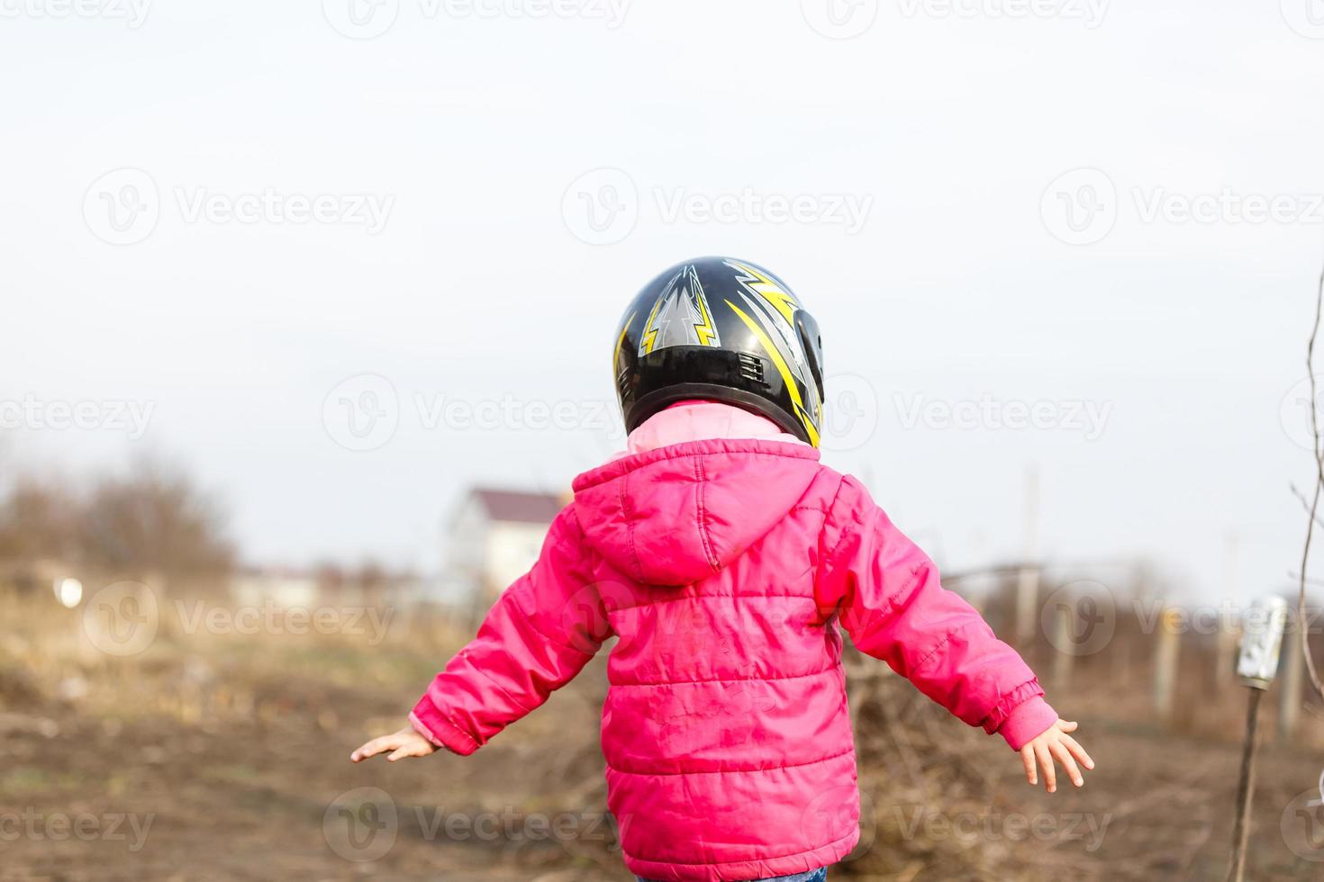 portrait of a little girl smiling in a protective helmet female child in motocross moto helmet. biker girl in motocross helmet photo