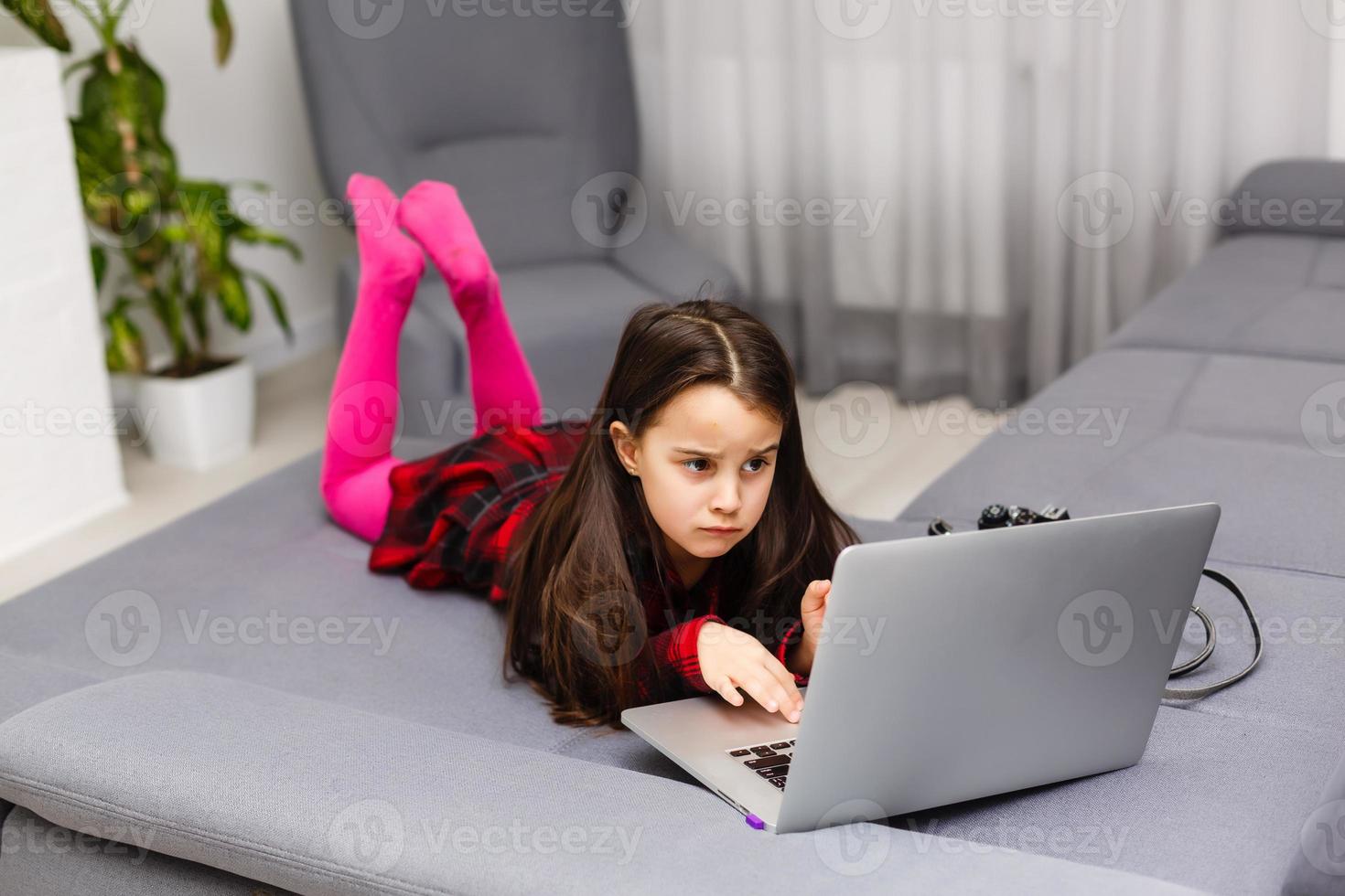 Happy little girl buying online at home, shopping online photo
